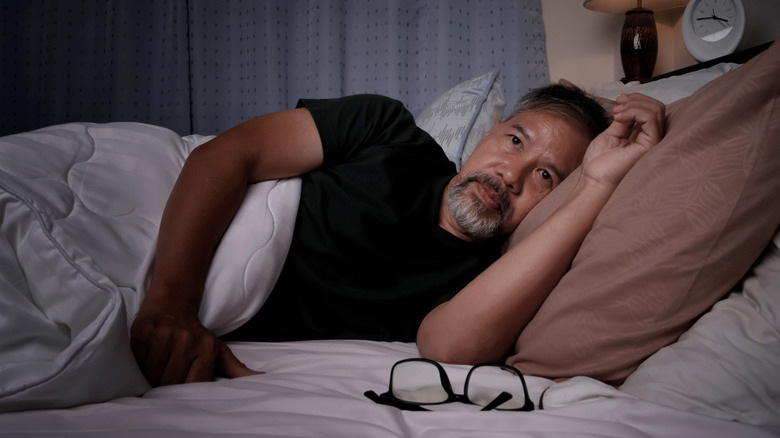 woman sitting at the edge of her bed