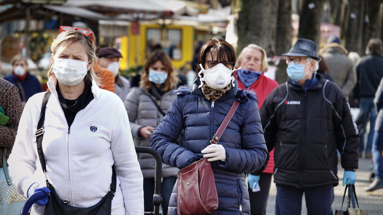 crowd of people walking with masks