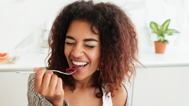 smiling woman eating fruit