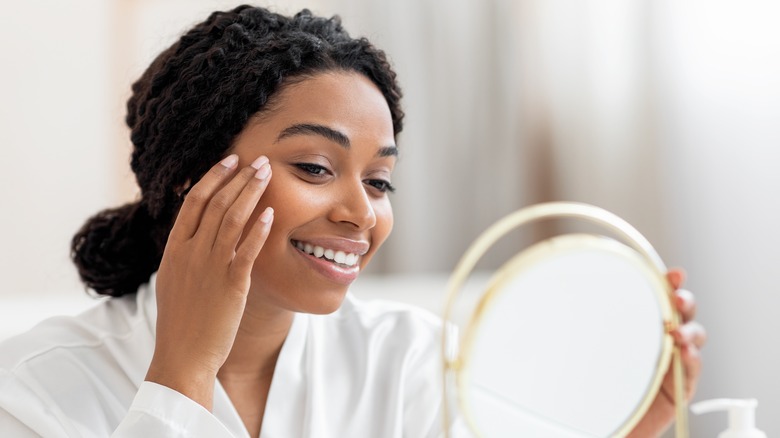 Smiling woman looking in mirror