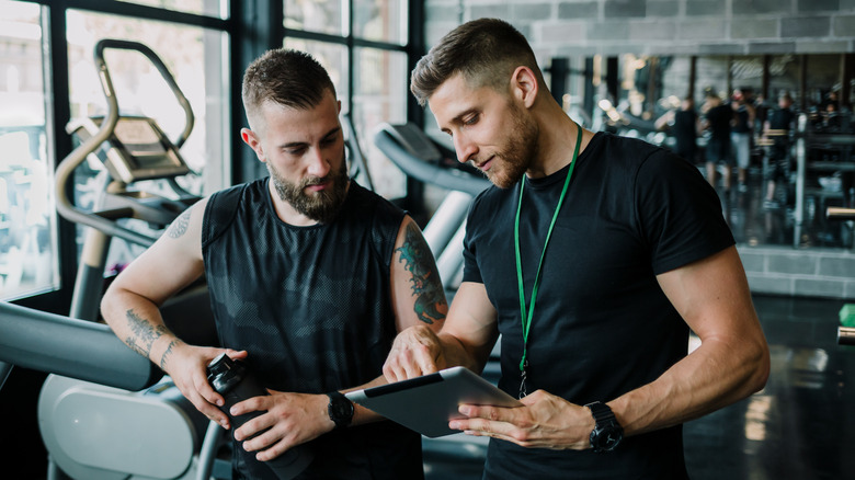 Trainer consulting with client in gym