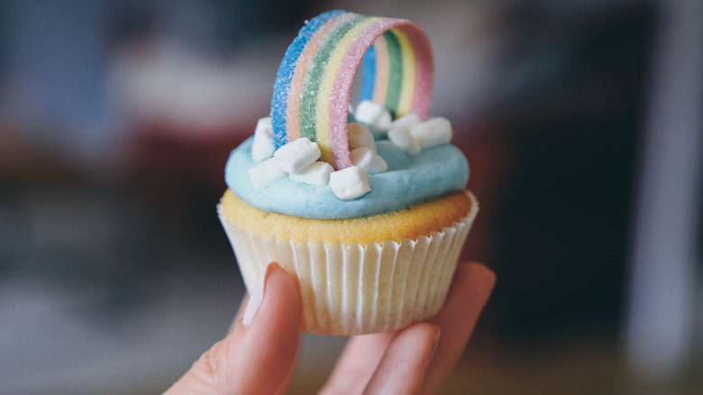 Hand holding cupcake with rainbow tape