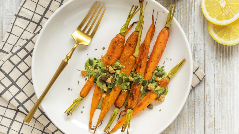 cooked carrots with avocado puree and pumpkin seeds