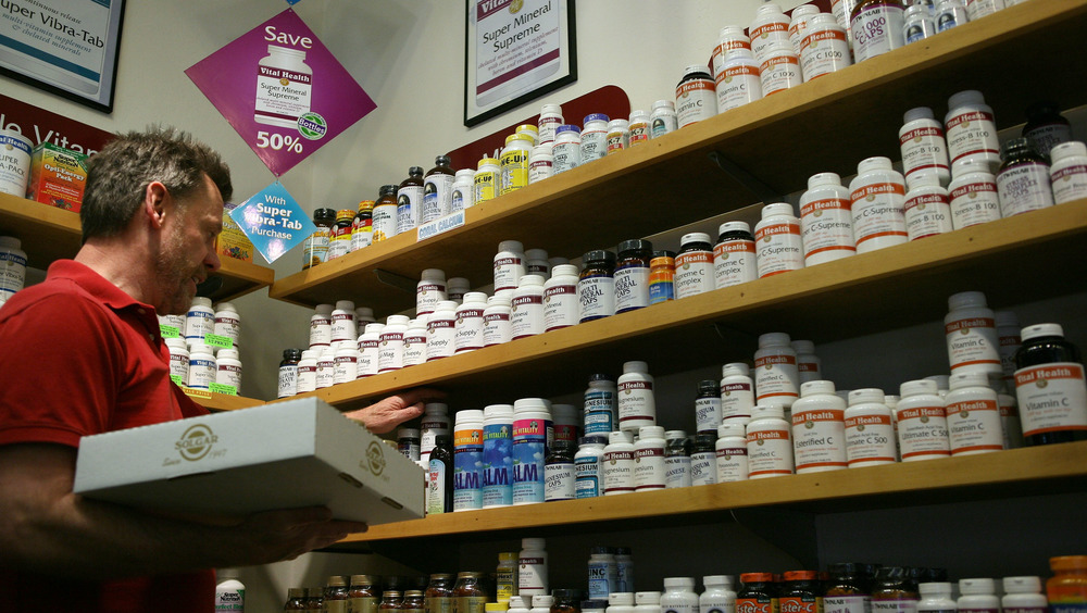 A man checks the stock of vitamins and supplements at a nutrition store