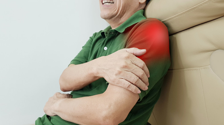 man holding his arm and grimacing