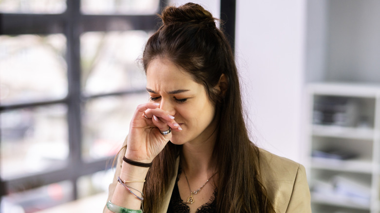Woman covering nose from foul odor