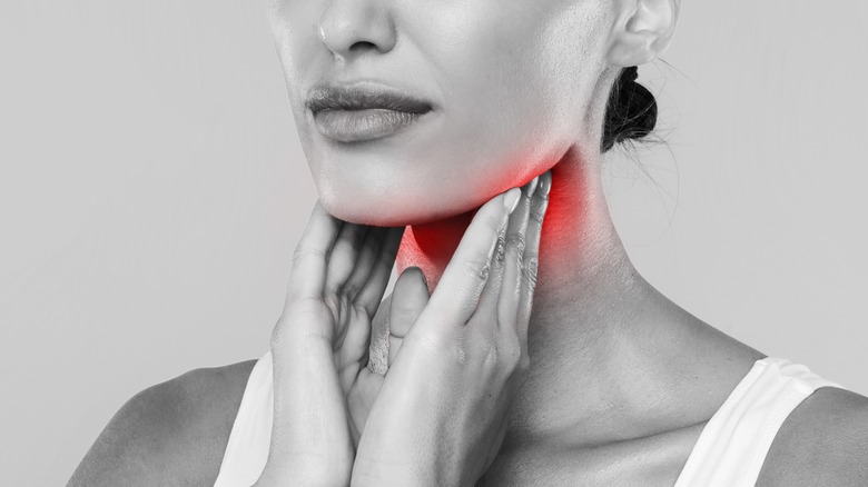 woman holding swollen tonsils