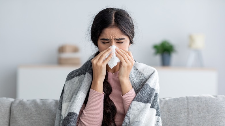 A woman blows her nose