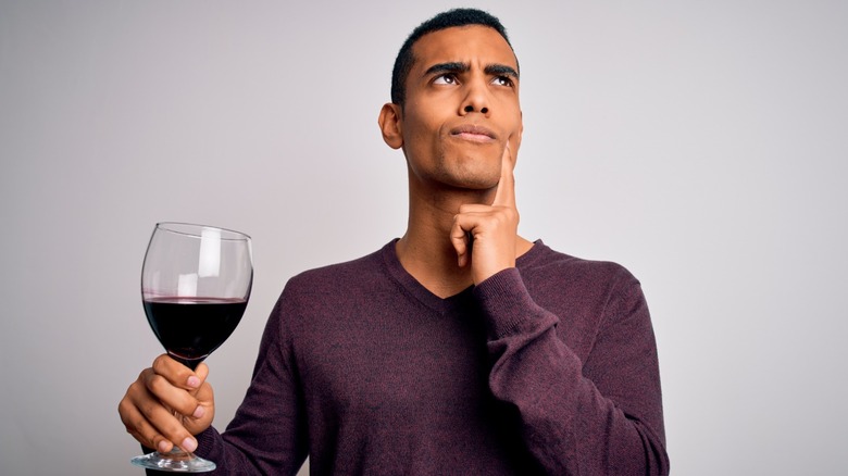 man holds glass red wine