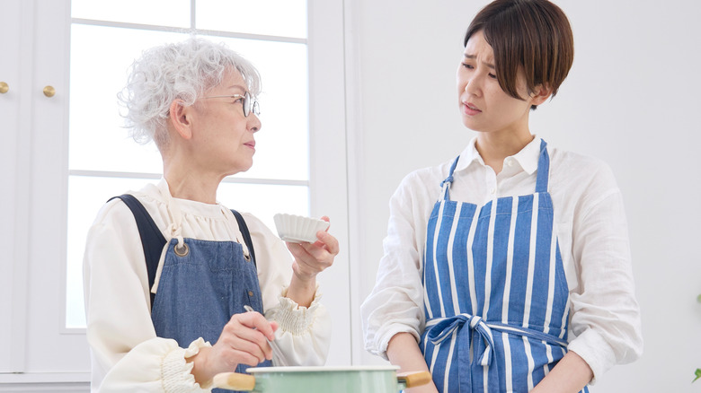 younger adult showing concern for older parent in the kitchen