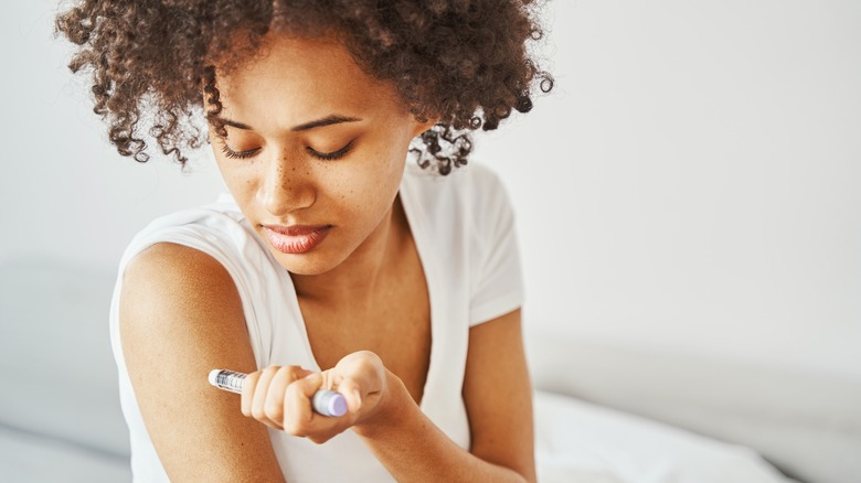 woman giving herself an injection