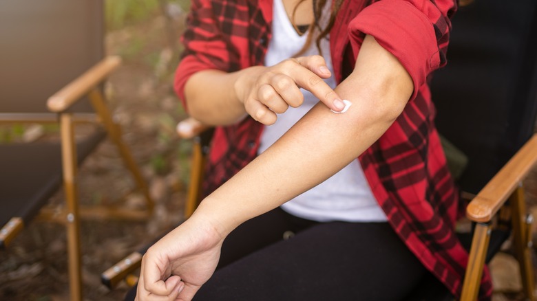Women dabbing cream on bug bite