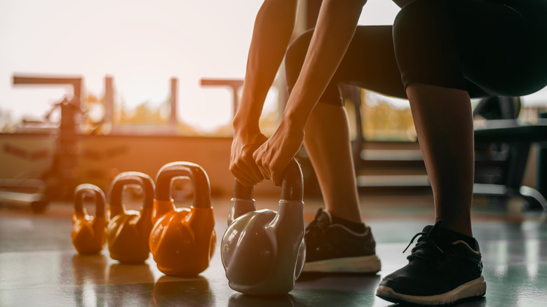 A person lifting a kettleball