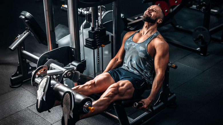 man doing leg extensions at gym