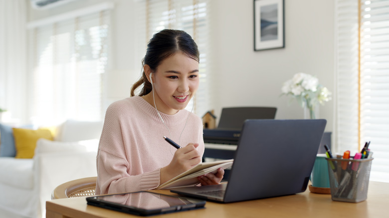 young woman sitting at computer writing