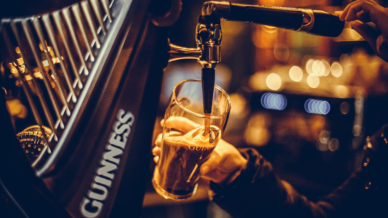 bartender pouring Guinness beer into glass