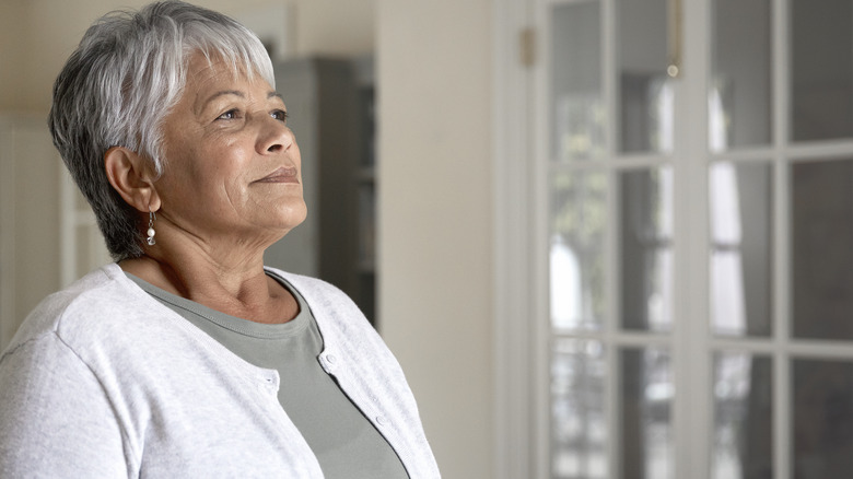 Woman taking a deep breath in kitchen