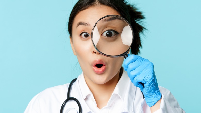 doctor looking through magnifying glass