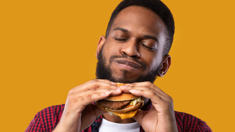 happy man eating cheeseburger