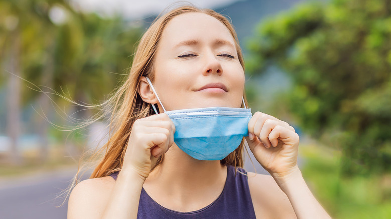 Woman breathing and removing mask