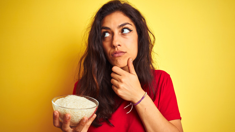 woman holds bowl of rice