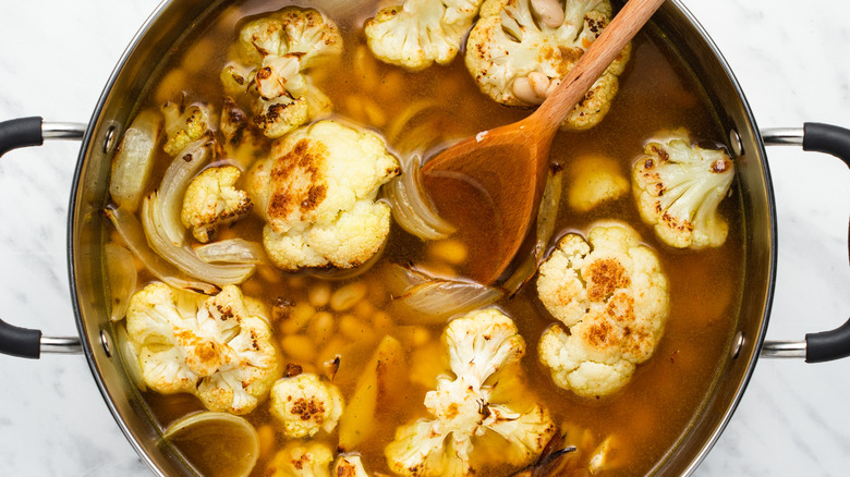 cauliflower onions beans broth in pot 