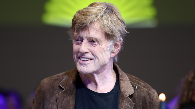 Robert Redford grinning at a large event