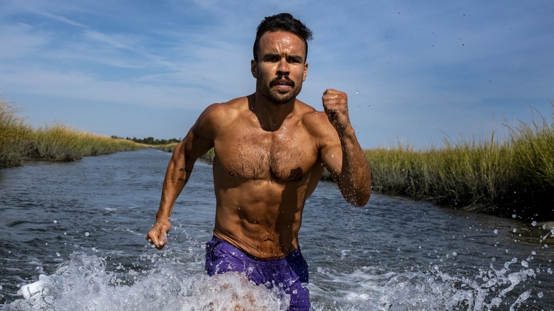 man running in water outdoors