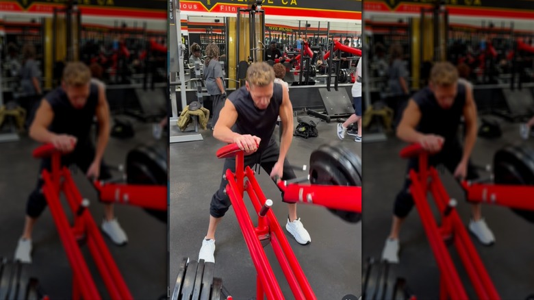 Ryan Seacrest working out his arms using plates and weight equipment
