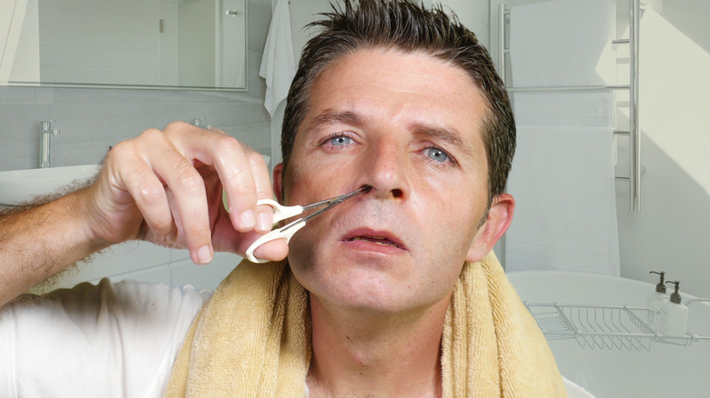 man removing nose hair