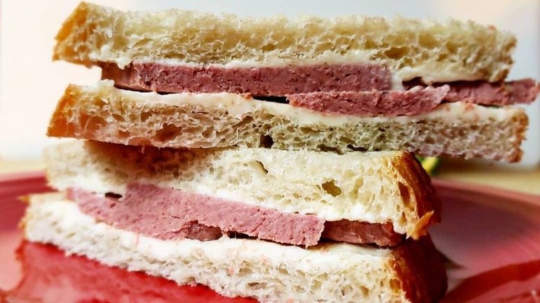 Two halves of Braunschweiger Sandwich served on a red plate