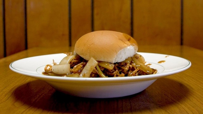 Chow Mein sandwich on burger bun in a white soup plate