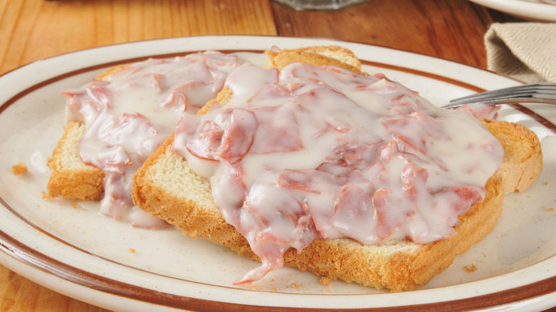 Creamed chipped beef on white bread toast on a wooden table