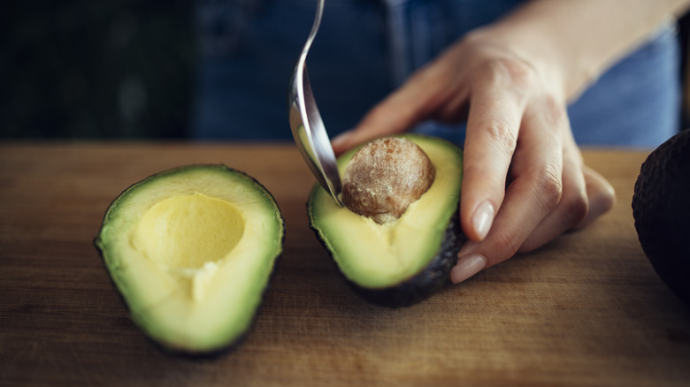 Spoon scooping out avocado pit