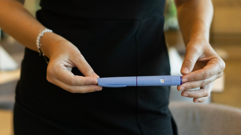 woman holding a weight loss injection pen