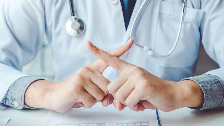 Doctor signaling no with hands