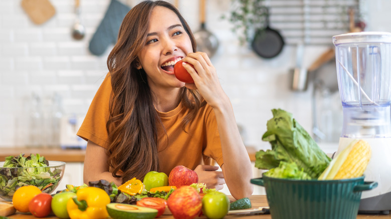 woman eating colorful array of fruits and vegetables