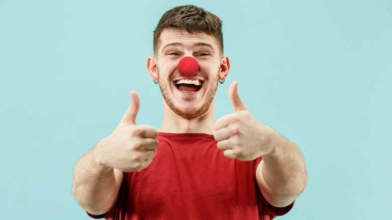 goofy young man wearing a clown nose