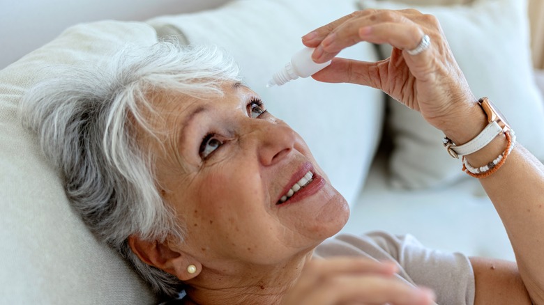 Older woman using eye drops