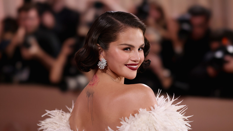Selena Gomez posing on the red carpet in white feathered gown