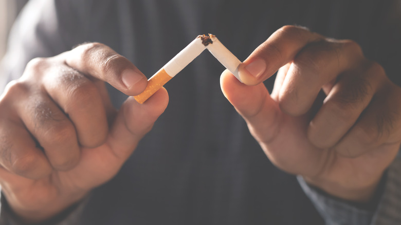 Man breaking a cigarette in half
