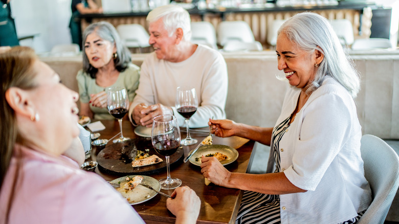 Seniors enjoying red wine with their meal