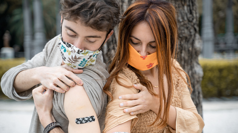 young adults showing vaccine band-aids