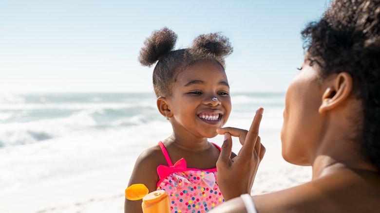 a mom putting sunscreen on a child