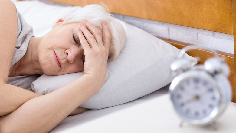 older woman lying in bed with insomnia