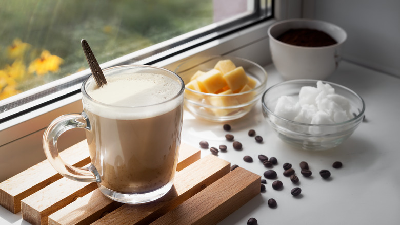 A cup of butter coffee next to the window