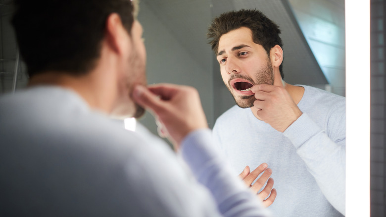 man looking inside his mouth