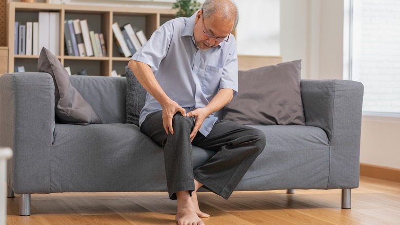 elderly man holding knee