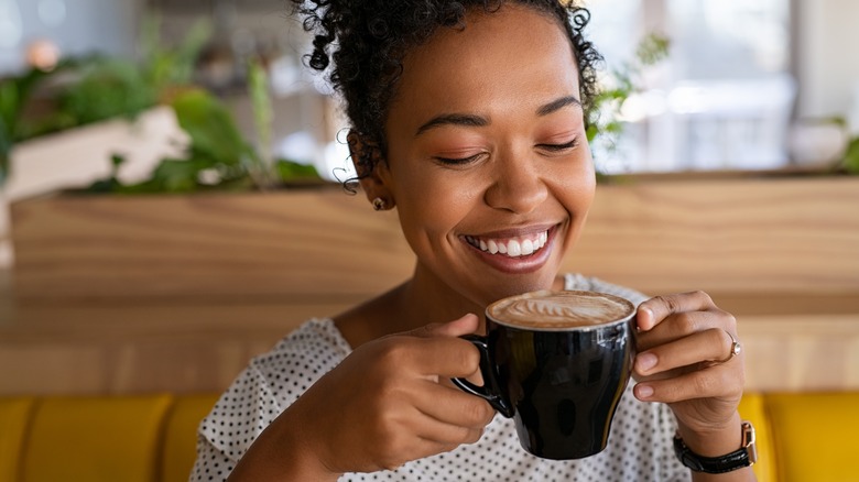 A woman drinks a cup of coffee