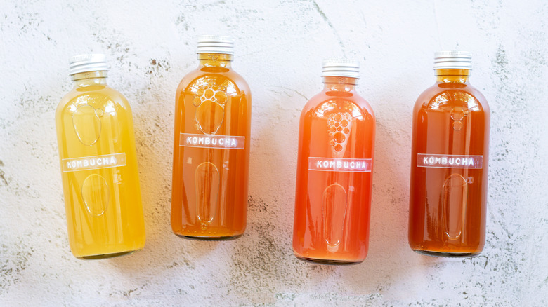 four bottles of kombucha on a white countertop 